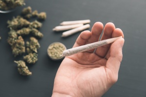 un homme apprend à fumer un joint